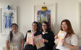 The group posing with their booklets