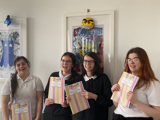 The group posing with their booklets
