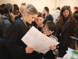 Two young people and their facilitator looking at a poster