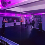 Youth group attending a dance class in a dark purple dance studio 