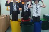 The group standing in recycling bins