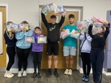 Young people holding wellbeing packs